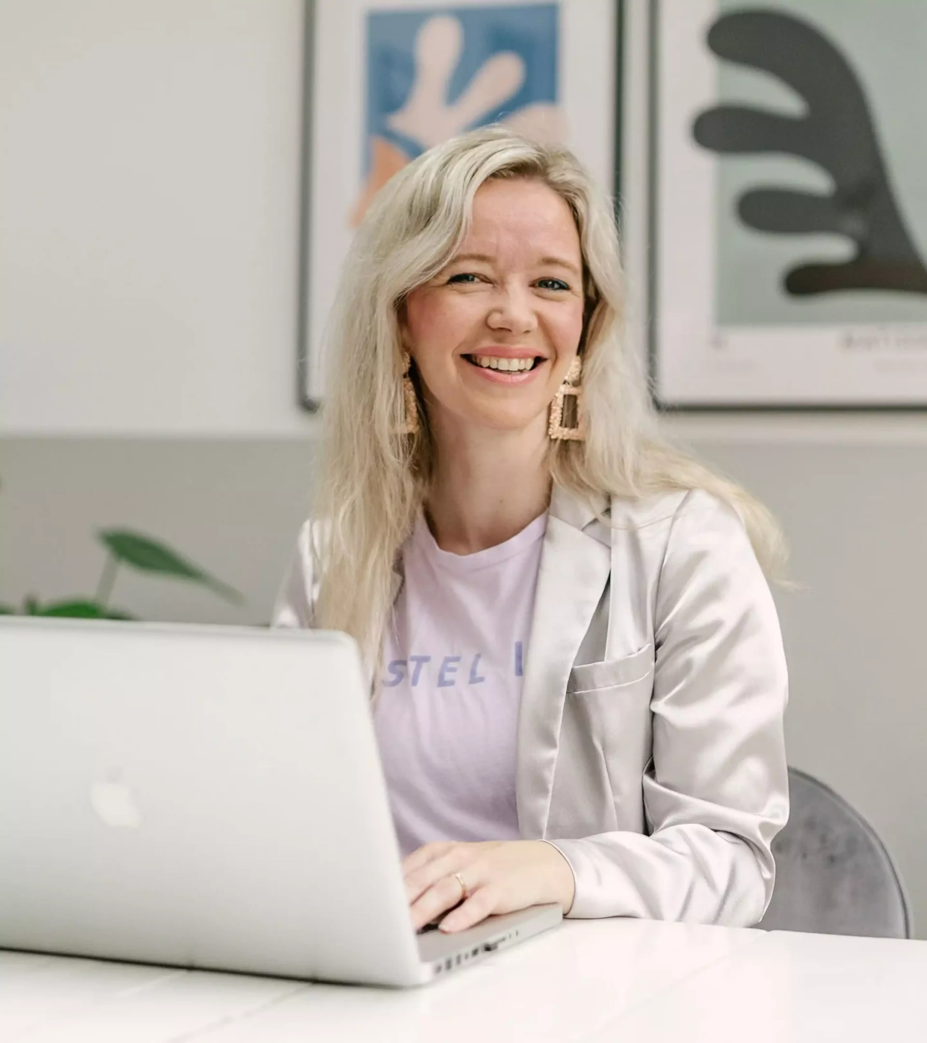 An image of a woman sitting at a desk behind her laptop