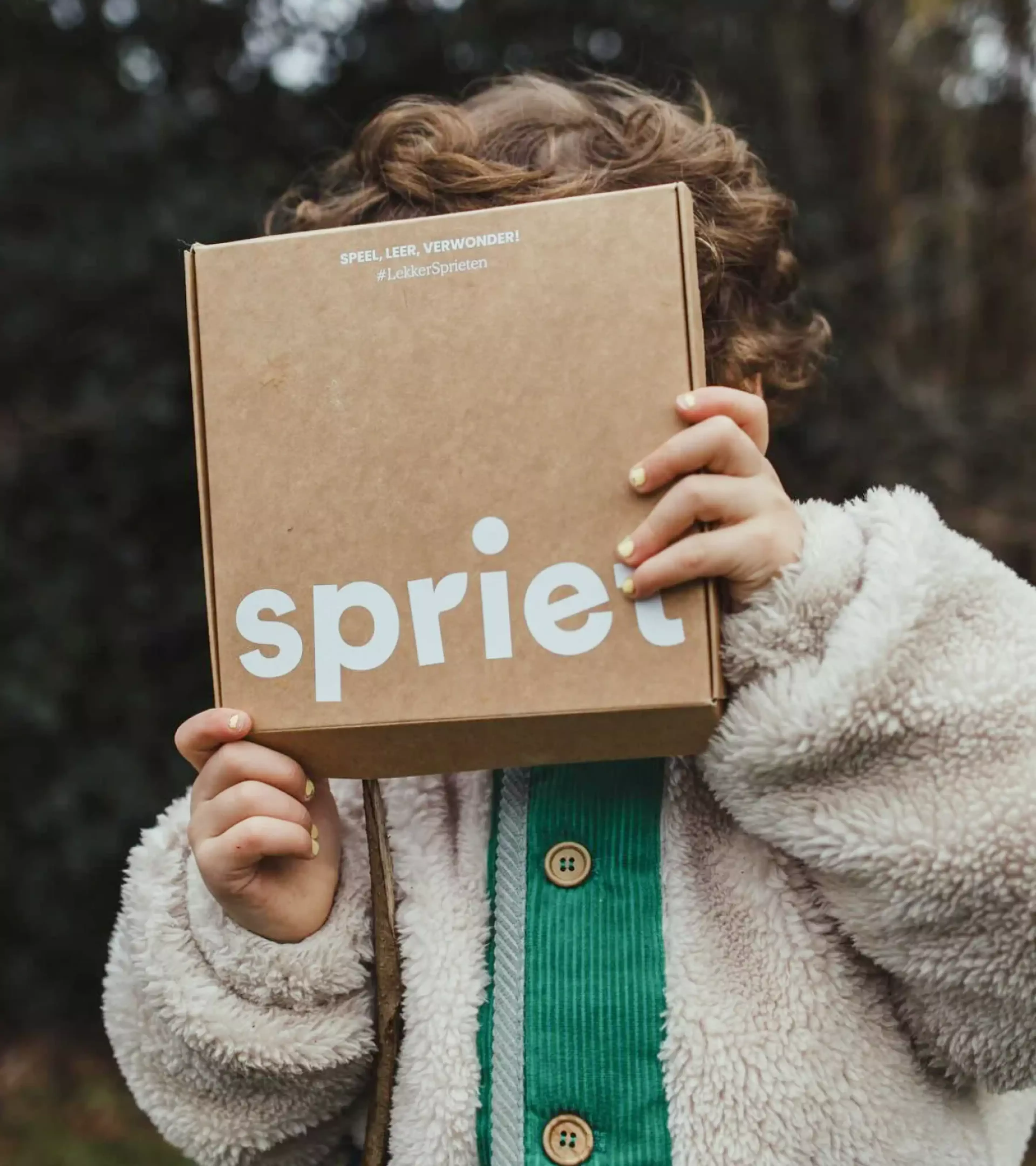 kid holding a spriet box in front of her face