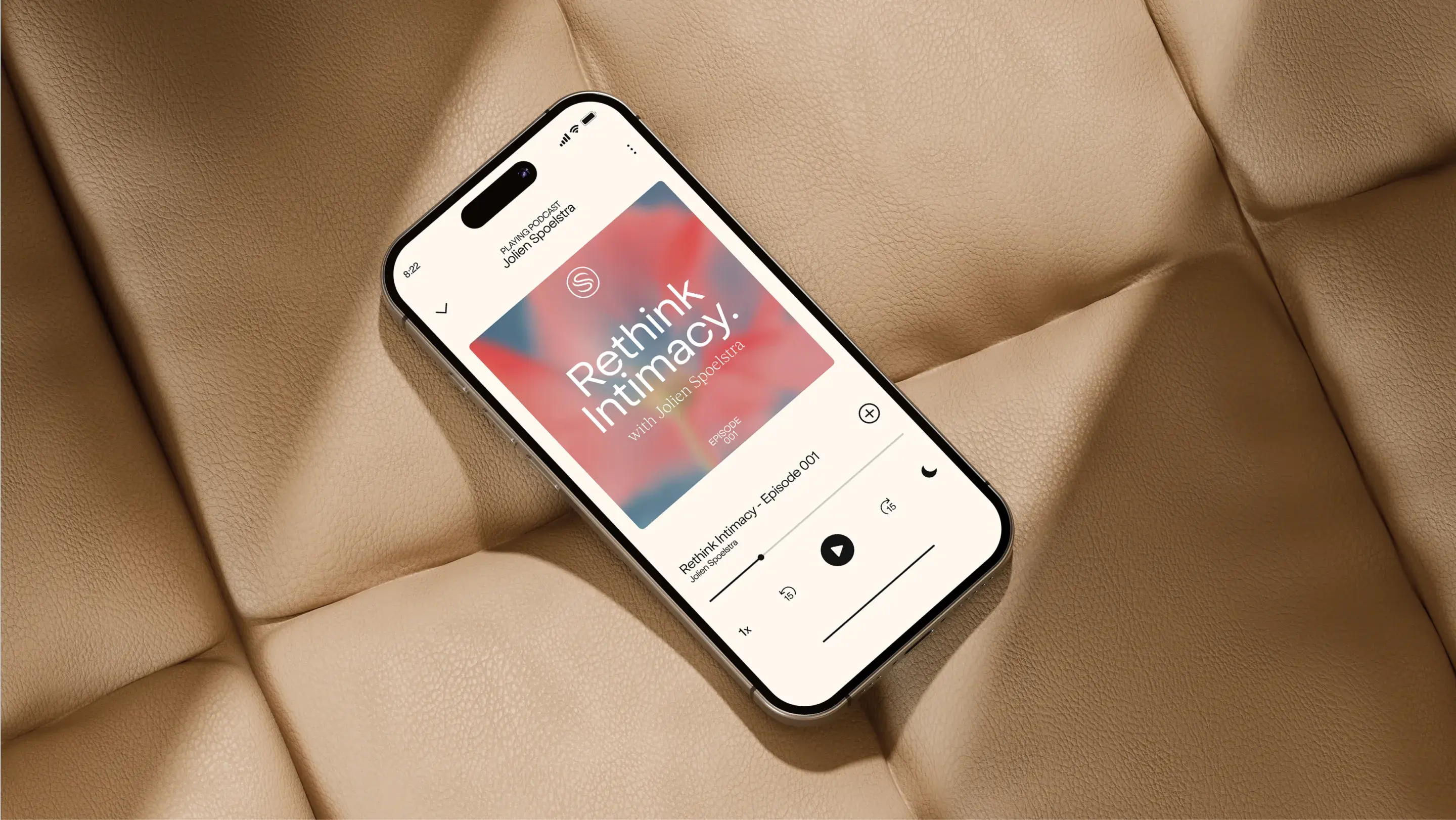 Smartphone on a beige cushion displaying a podcast titled "Rethink Intimacy!" with a blurred background and playback controls visible.